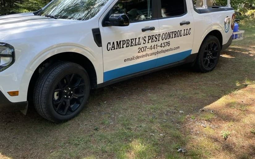 Campbell's Pest Control branded work truck parked among trees in Palmyra, Maine