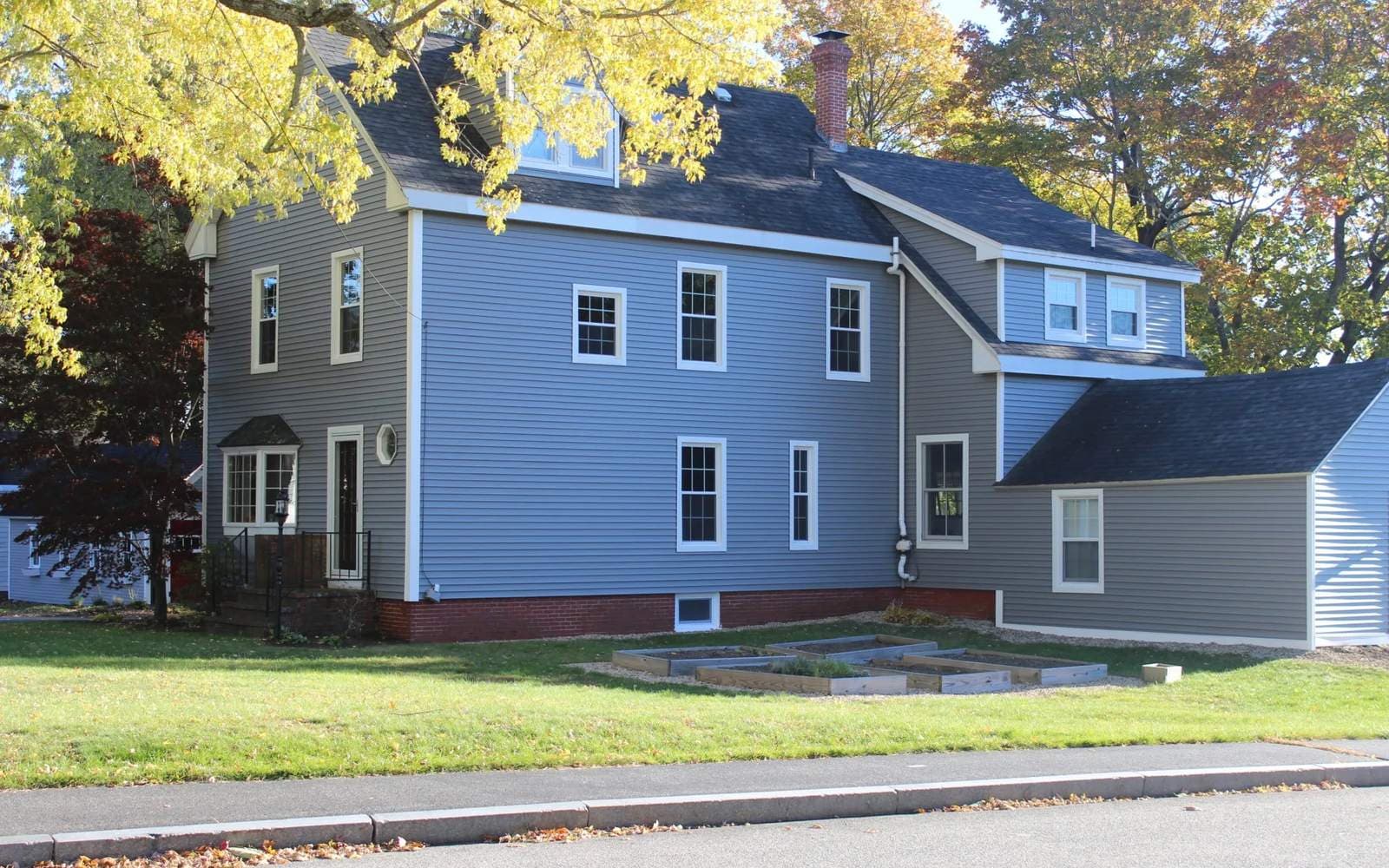 Farmhouse with newly installed siding and roofing by Cardinal Exteriors in the North Deering neighborhood of Portland, Maine