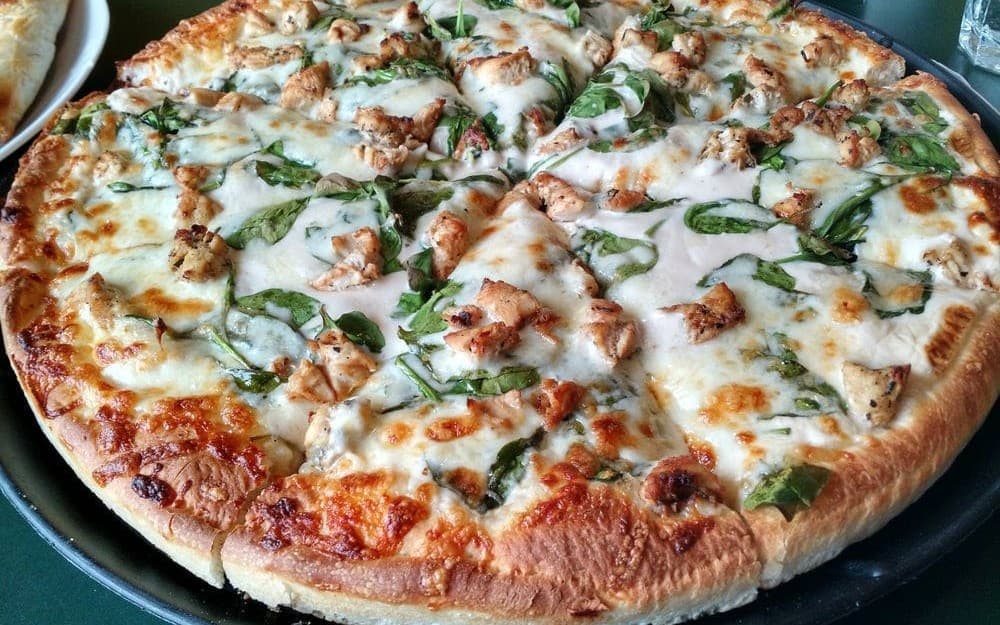 Fresh Greek-style pizza topped with chicken, spinach, and cheese from Kozeta's in Westbrook, Maine