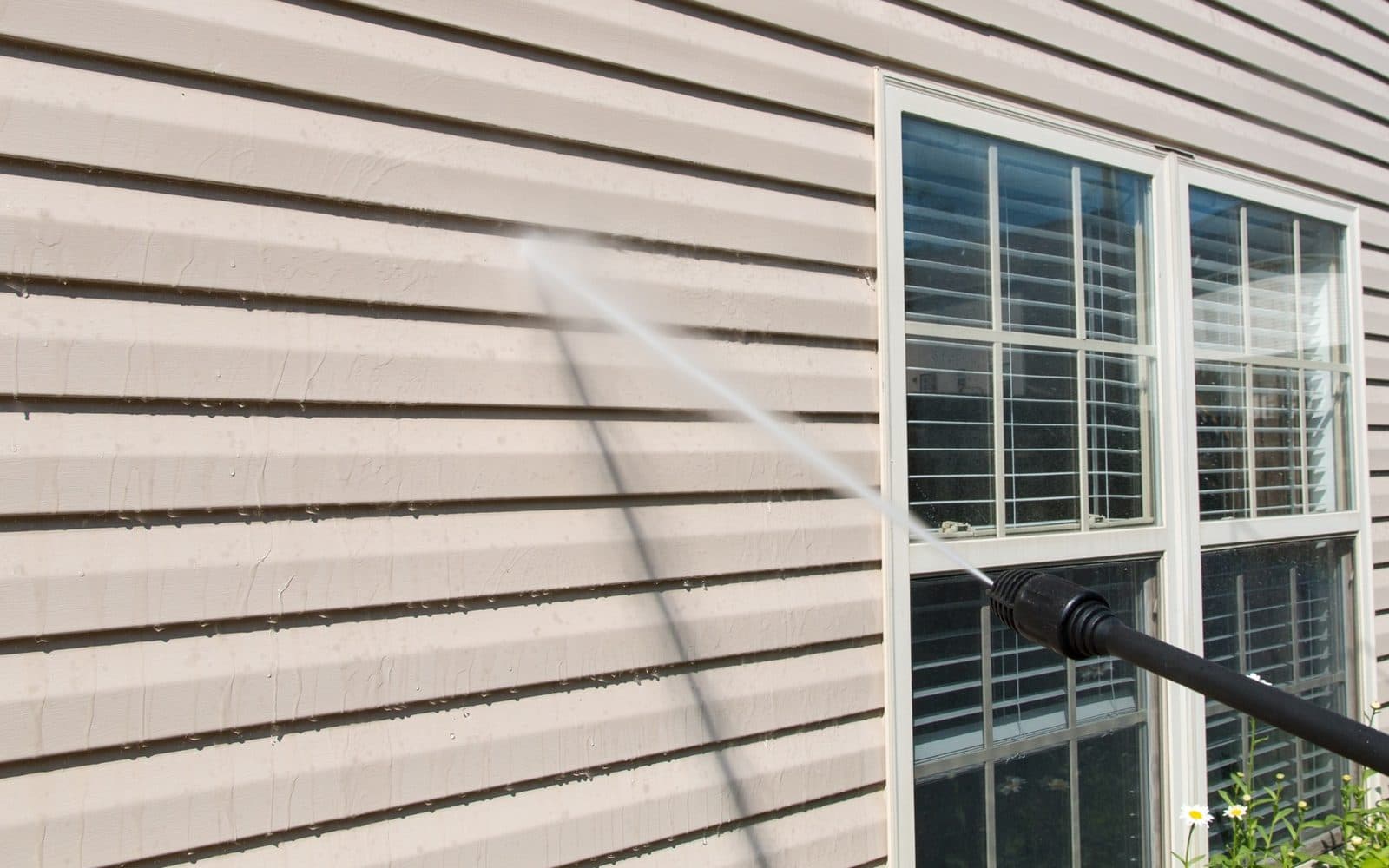 Pressure washing siding and a window on a home, Streak Free Solutions